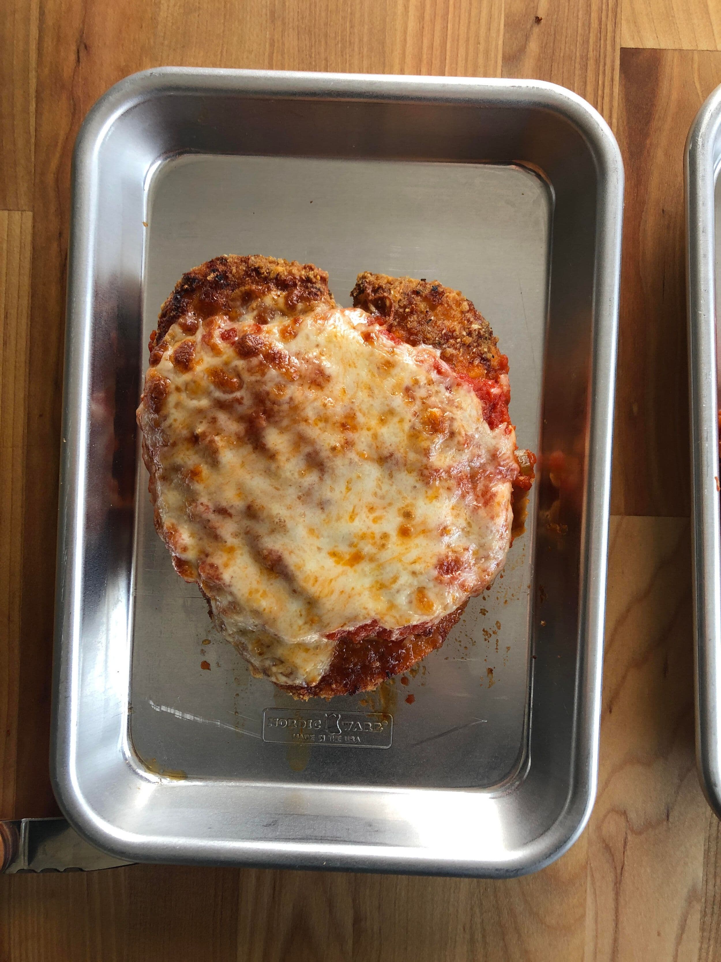 Breaded fried chicken breast with red sauce and melted mozzarella.